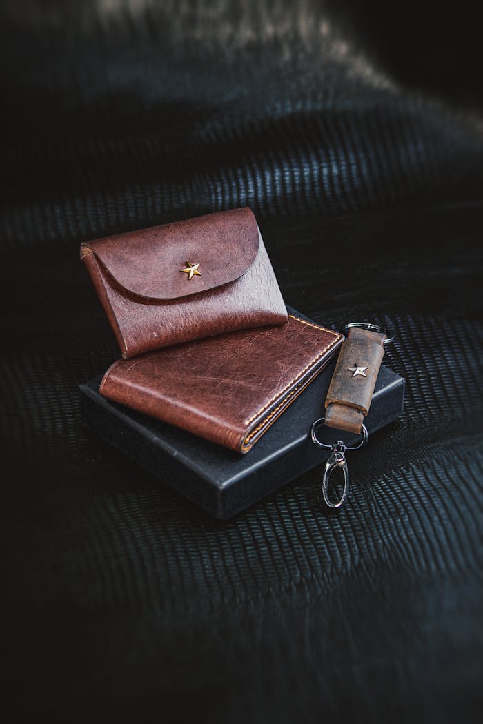 Premium leather wallet and keychain set on a black background. Sophisticated men's fashion accessory.